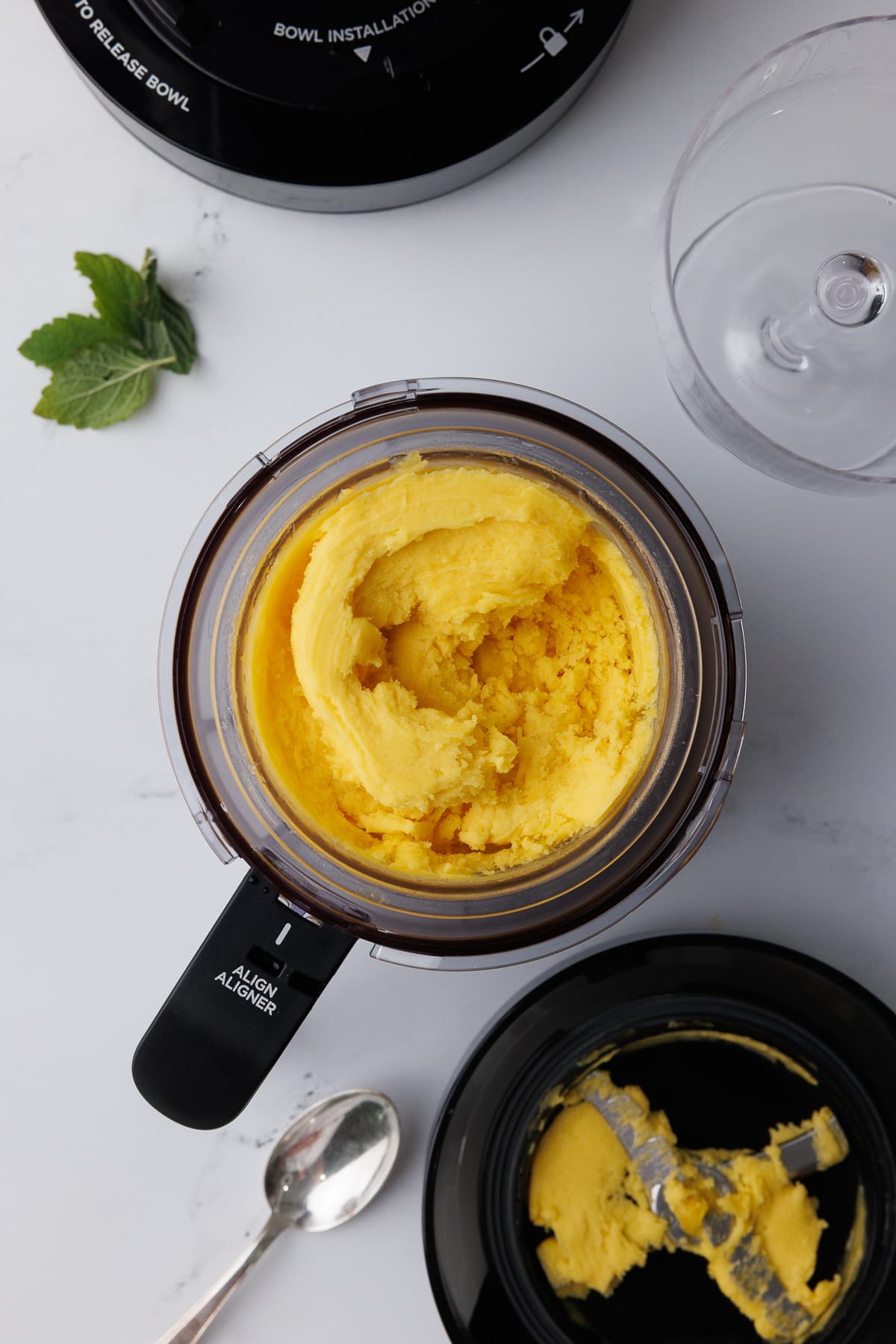 overhead photo of mango sorbet in a champagne flute with ninja creami pint jar,