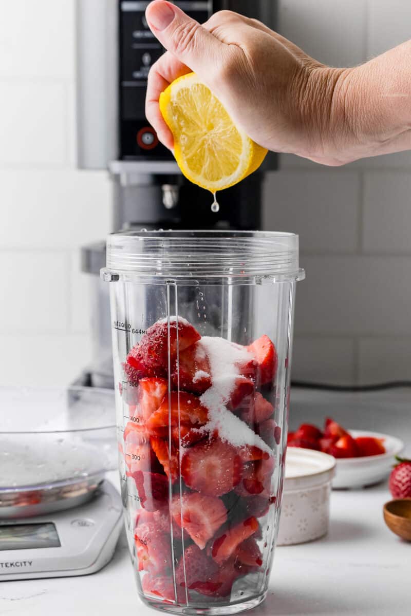 strawberries, sugar, and lemon in a blender