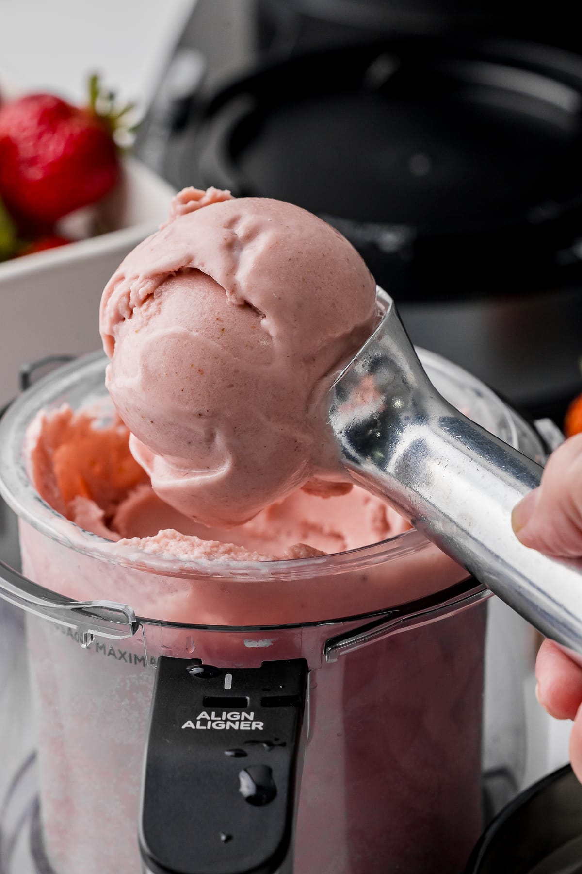 Stainless steel ice cream scoop with a scoop of strawberry banana ice cream