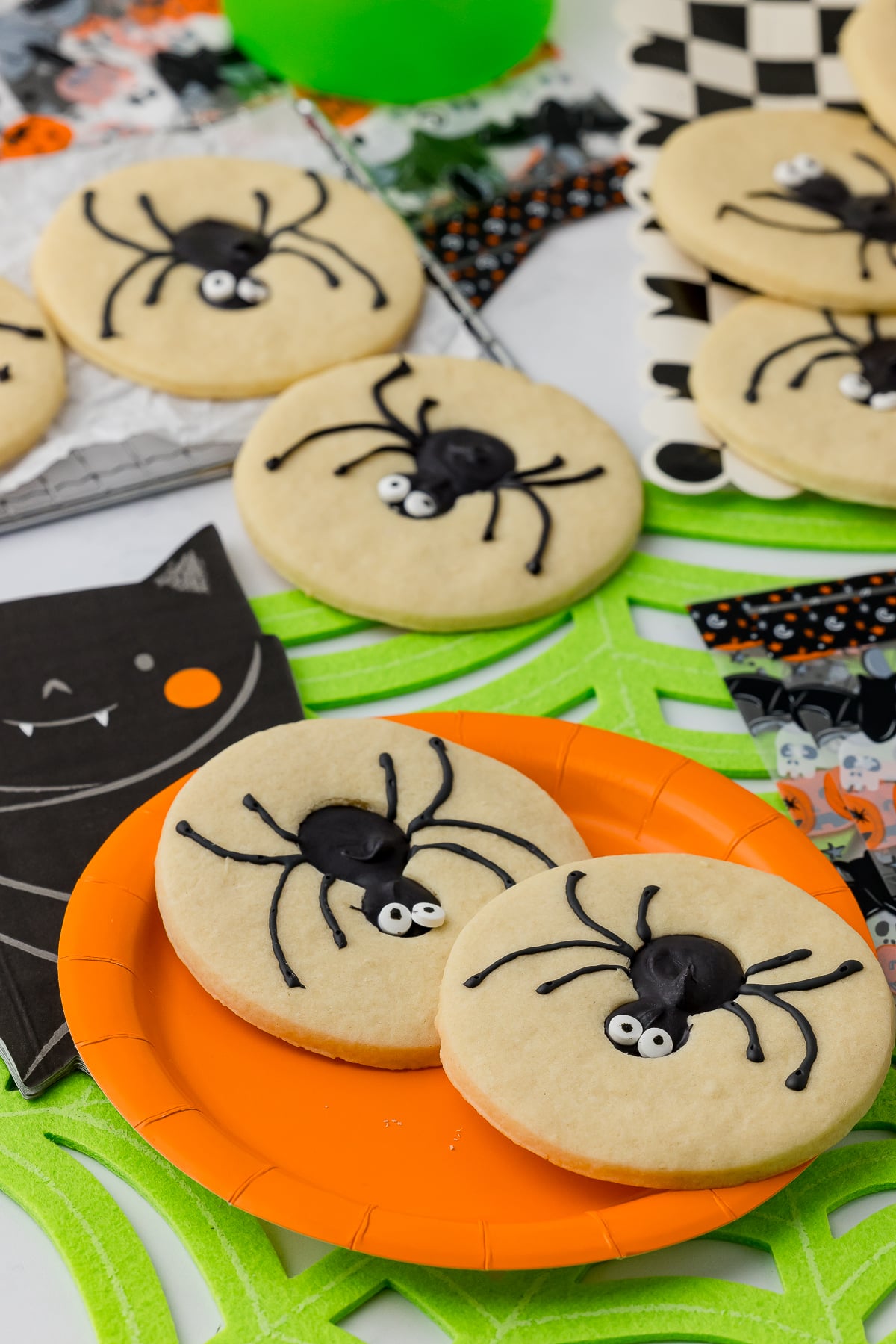 ugar cookies, a checkered square plate, ghost napkin and a neon green spiderweb