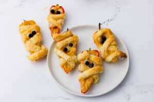 puff pastry wrapped tricolor poppers on a countertop and on a white plate