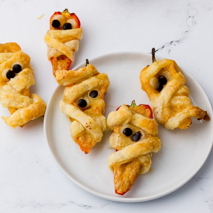 puff pastry wrapped tricolor poppers on a countertop and on a white plate