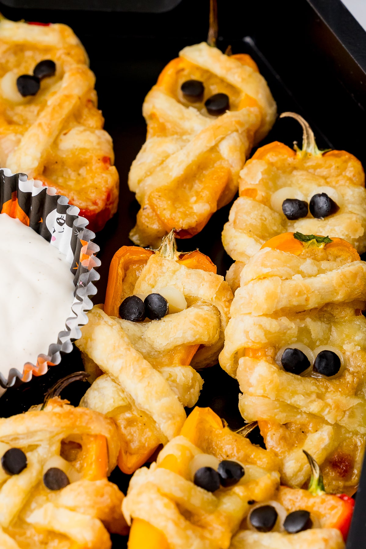 close up of baked halloween mummy poppers