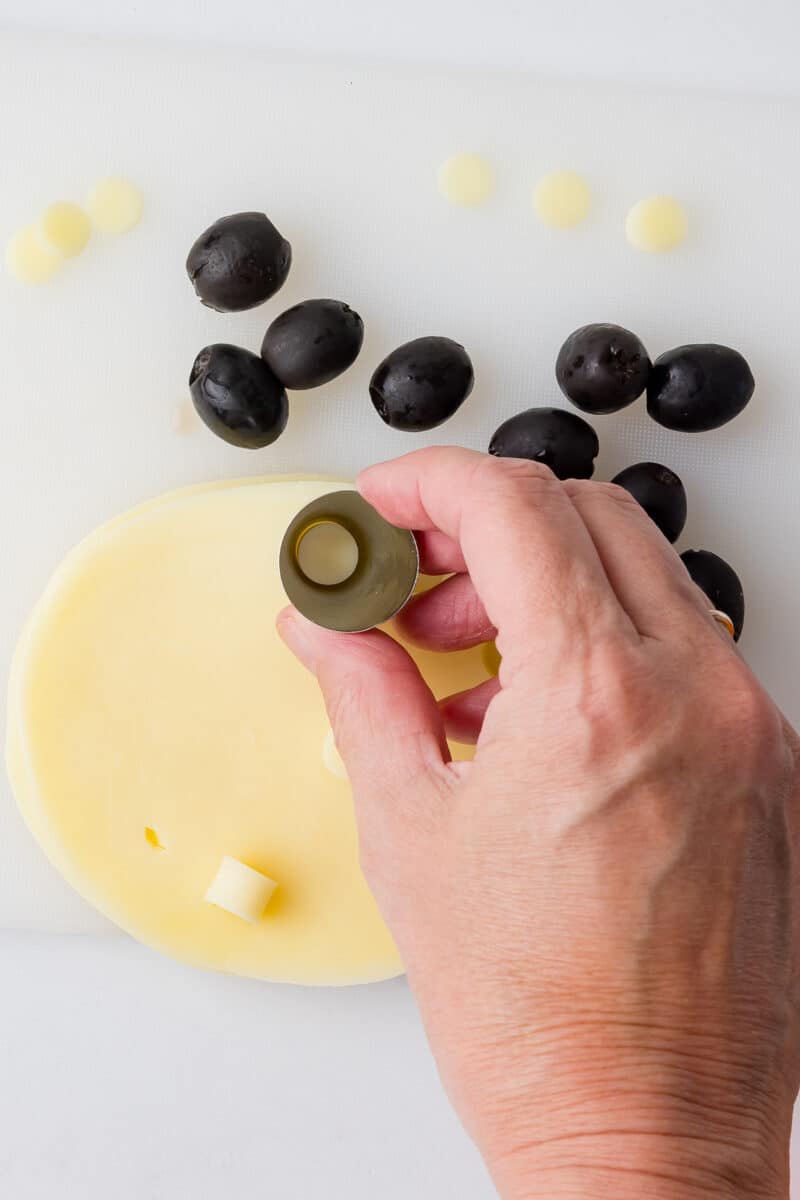 cutting small holes out of provolone cheese with a wilton piping tip