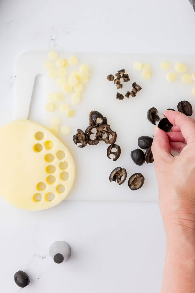 cutting small holes in black olives with a wilton piping tip