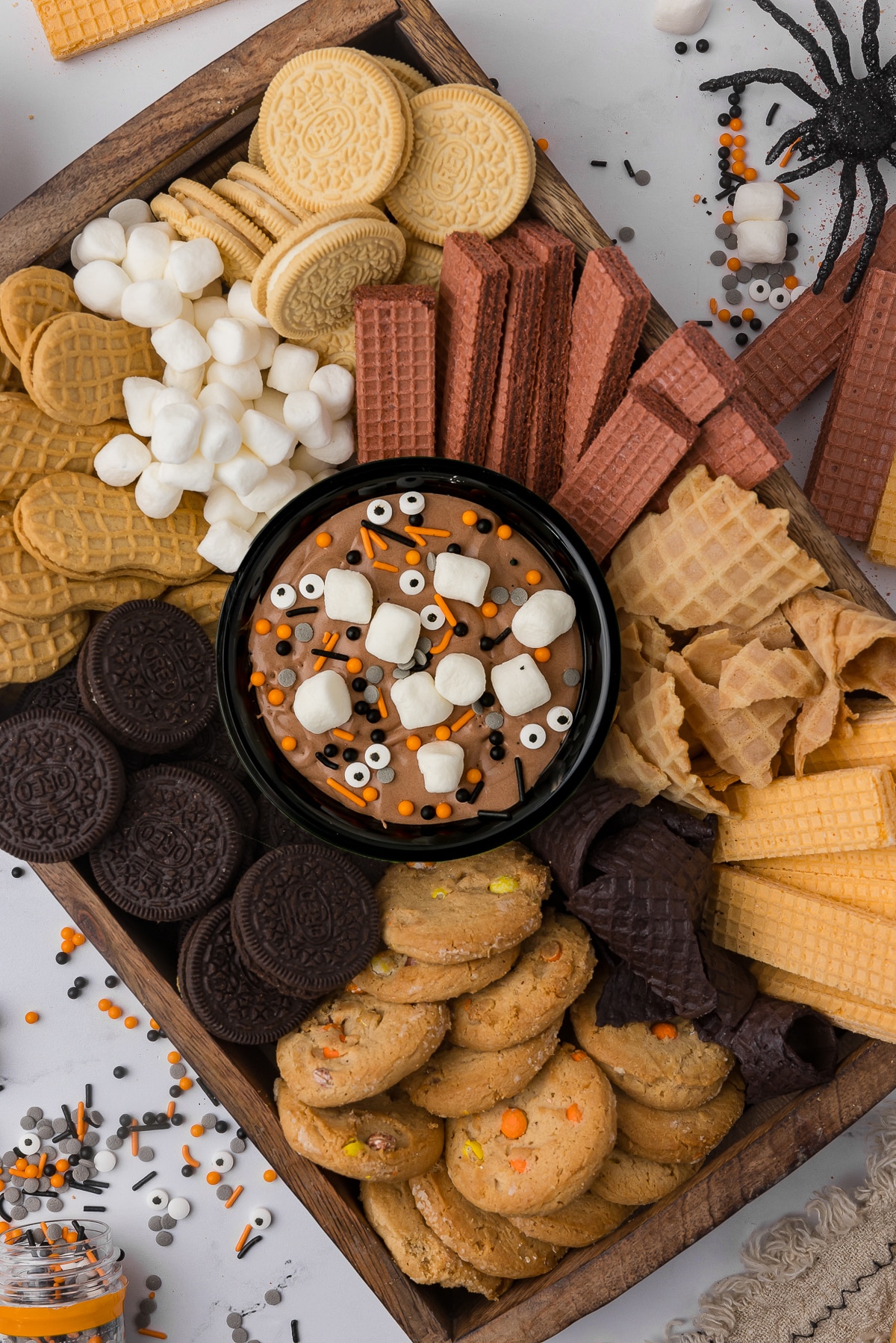 A fun charcuterie cookie platter with a bowl of homemade hot cocoa dip in the middle