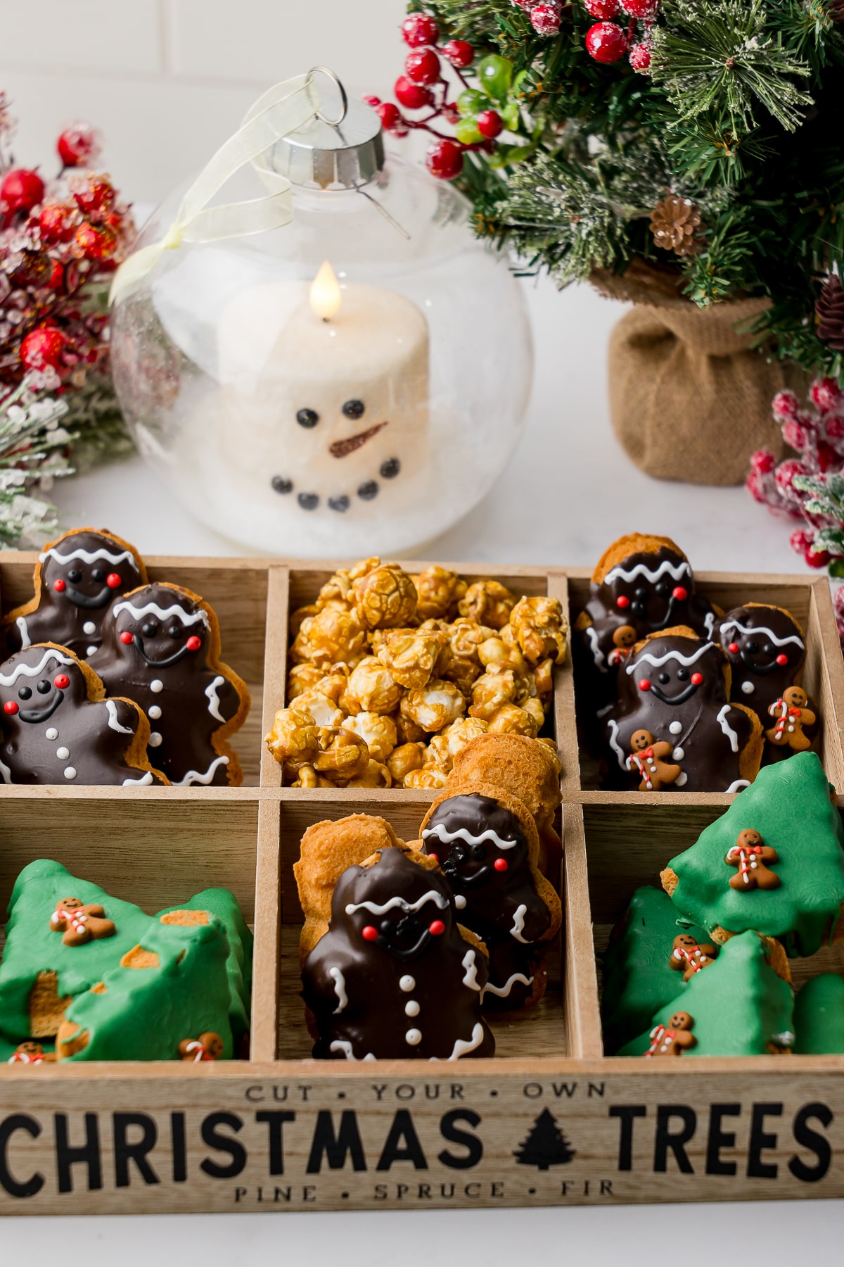 Festive tray of homemade Christmas cookies with holiday decor and candle