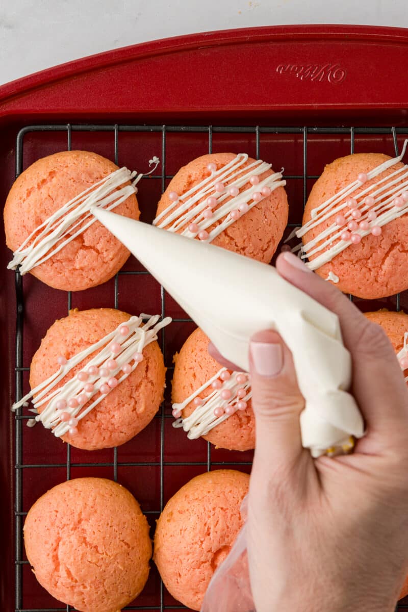 white chocolate being drizzled over cookies