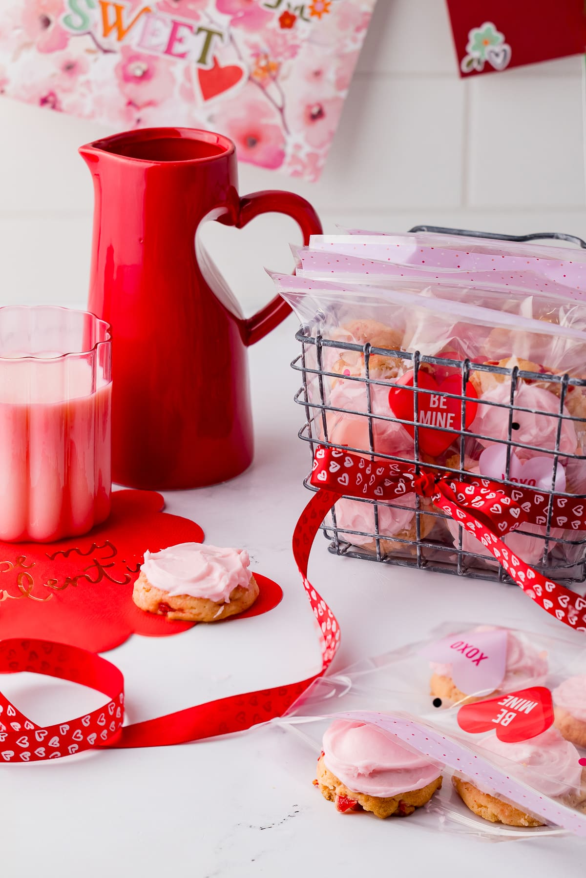 cherry cookies in Wilton Valentine's Day treat bags in a wire basket, red heart pitcher