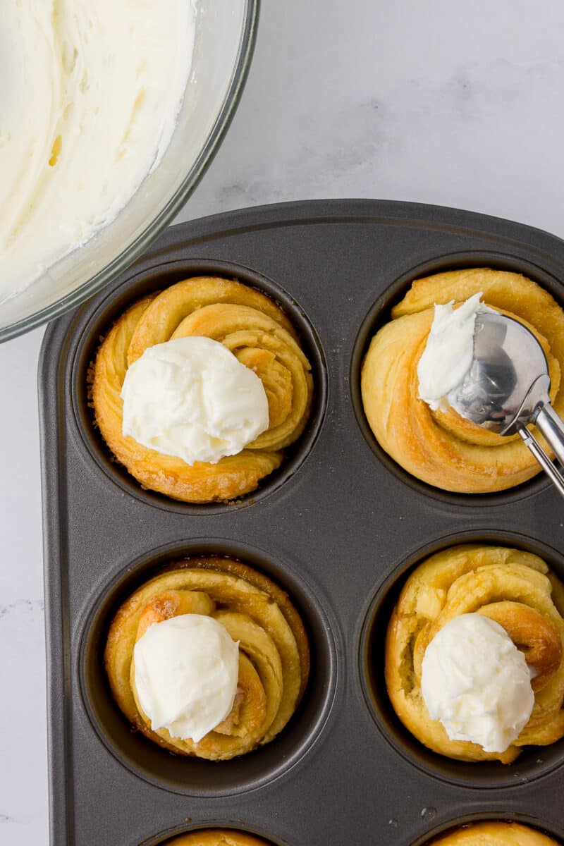 dollops of frosting on top of warm lemon rolls