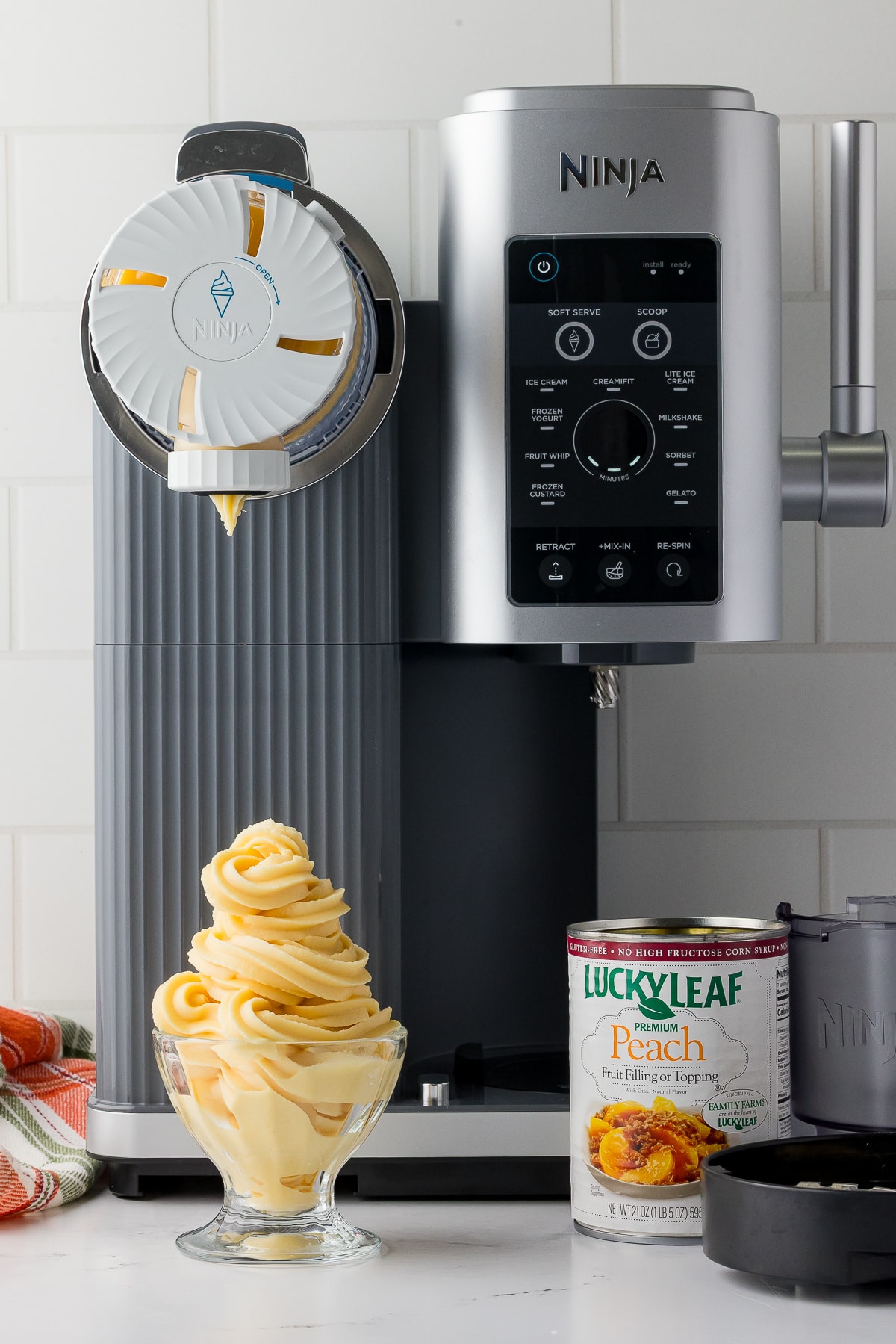 peach sorbet in front the of the ninja swirl by creami with a can of leuckyleaf peach filling