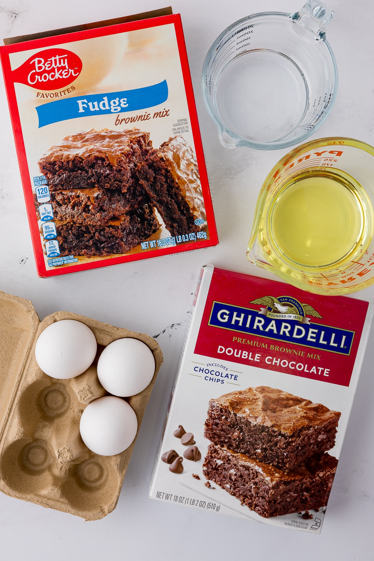 ingredients for the brownies including betty crocker fudge brownie mix, Ghirardelli double chocolate brownie mix, 3 eggs, water, and oil