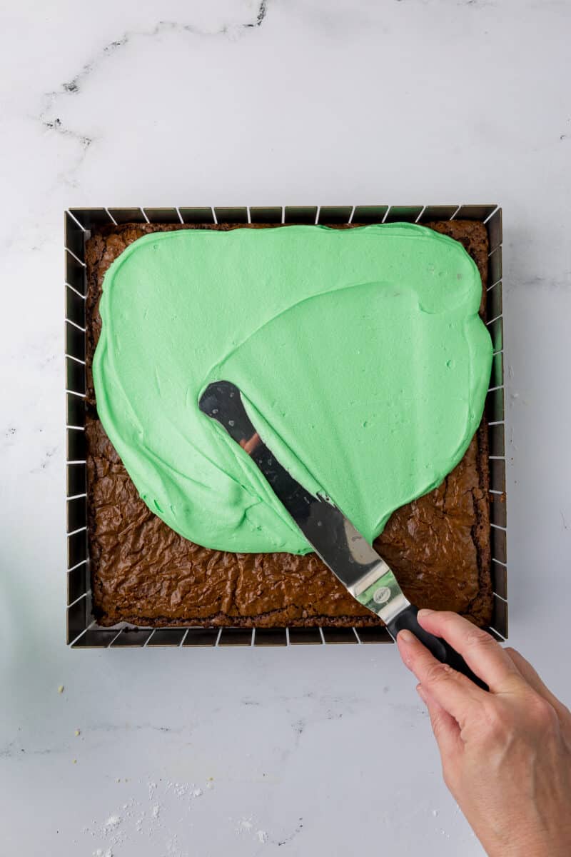 spreading green mint frosting on brownies