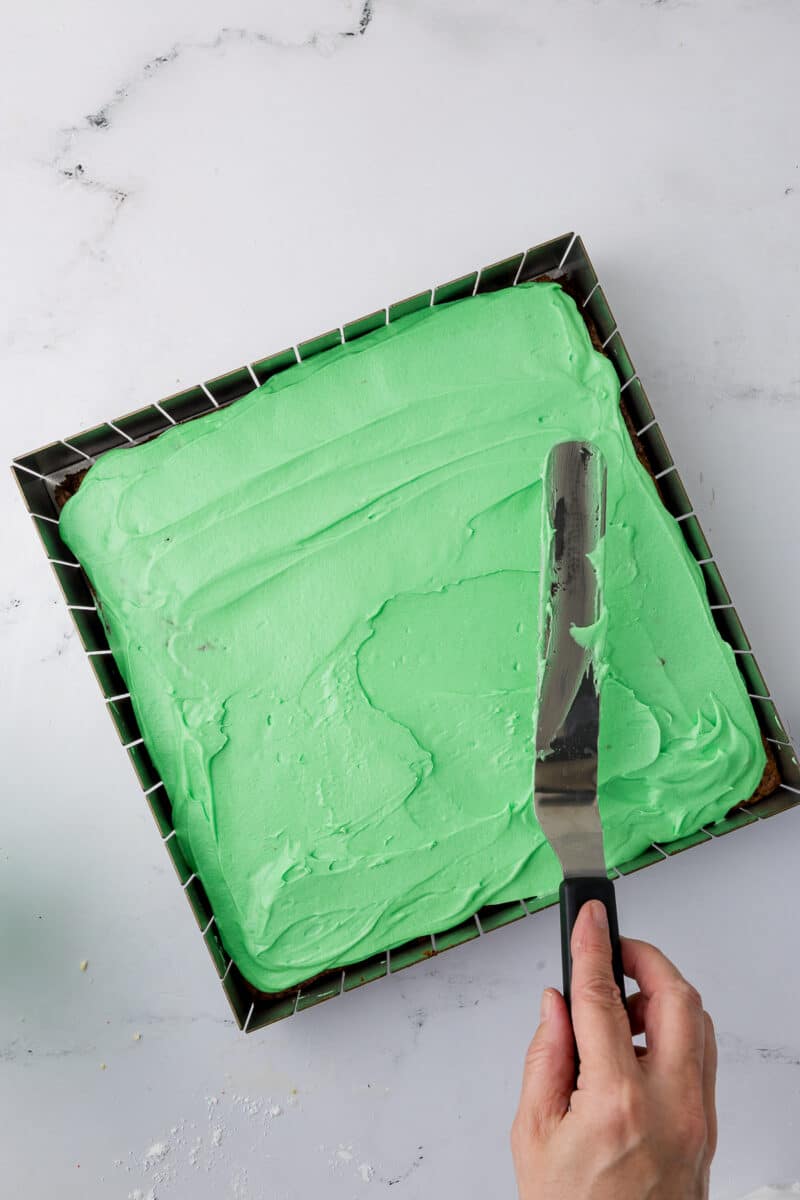 spreading mint frosting on brownies