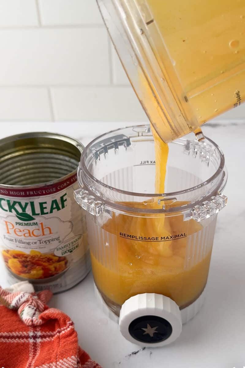 pouring blended peach fruit filling into creami pint jar