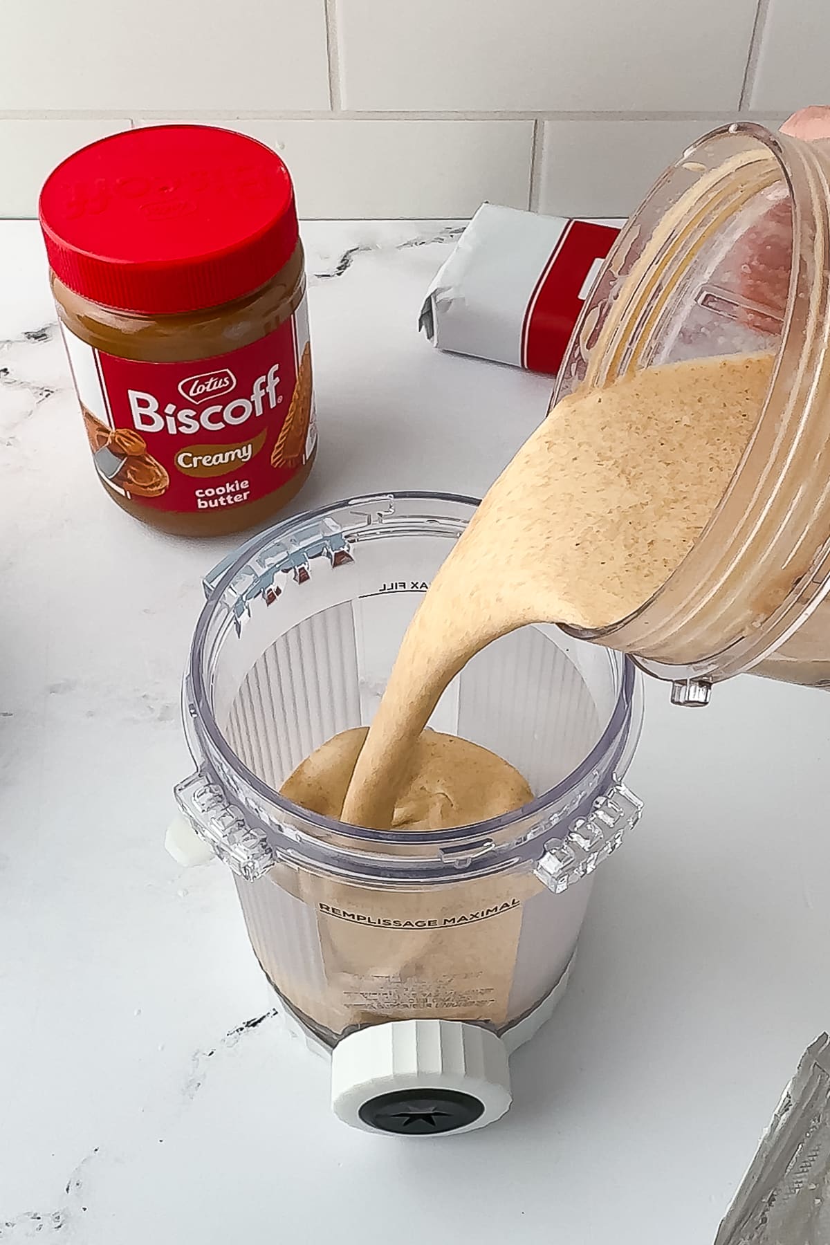 pouring biscoff ice cream mixture into ninja swirl pint jar
