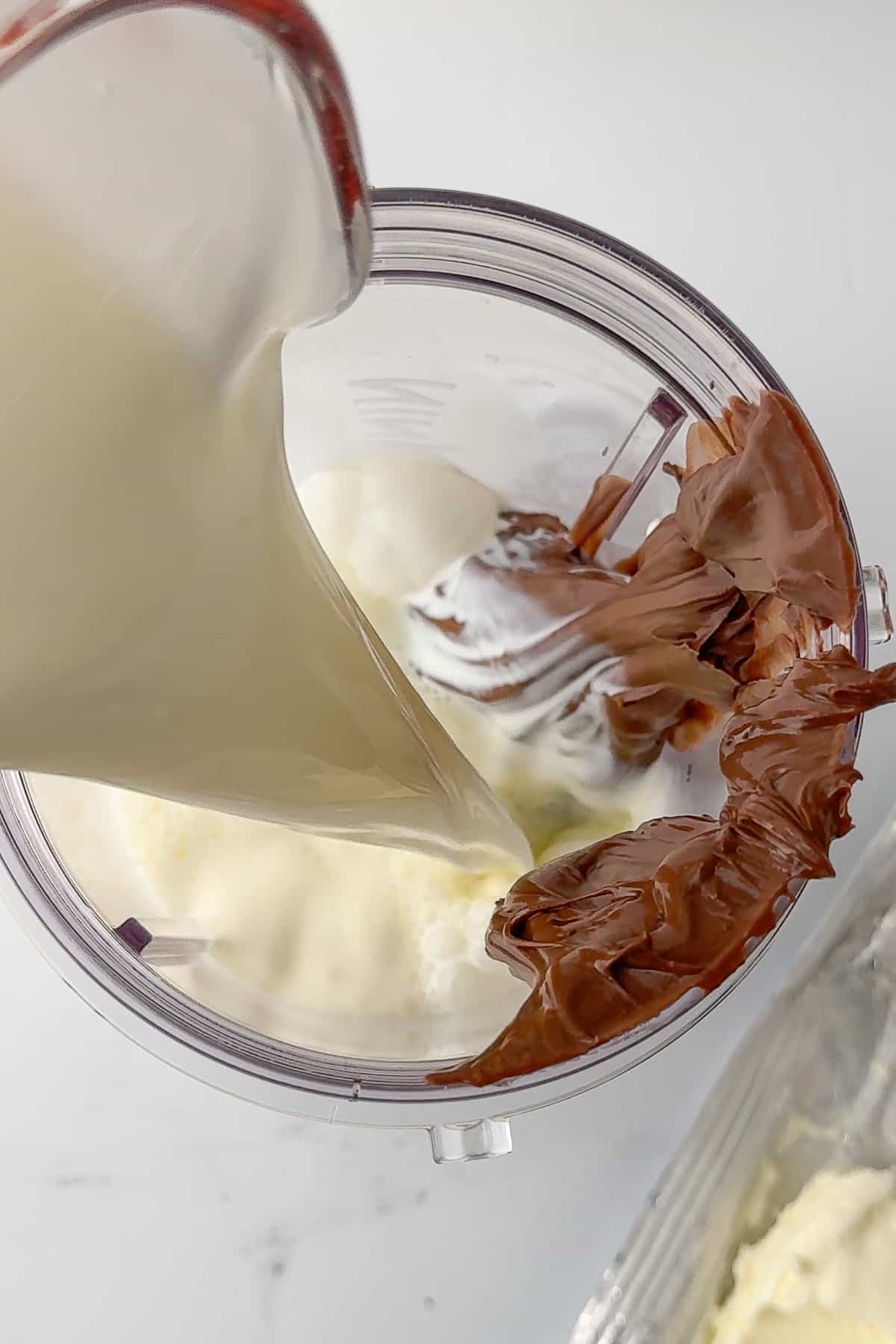pouring milk into a blender for the nutella ice cream mixture