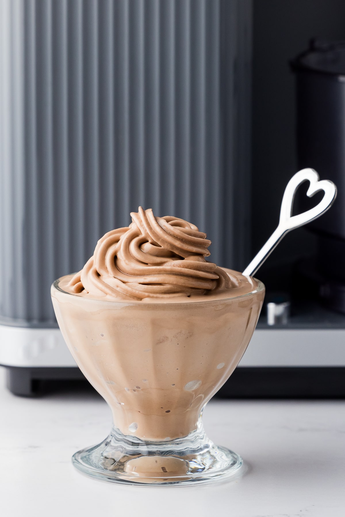 nutella soft swerve ice cream in a sundae bowl in from of the ninja swirl by creami with a heart spoon