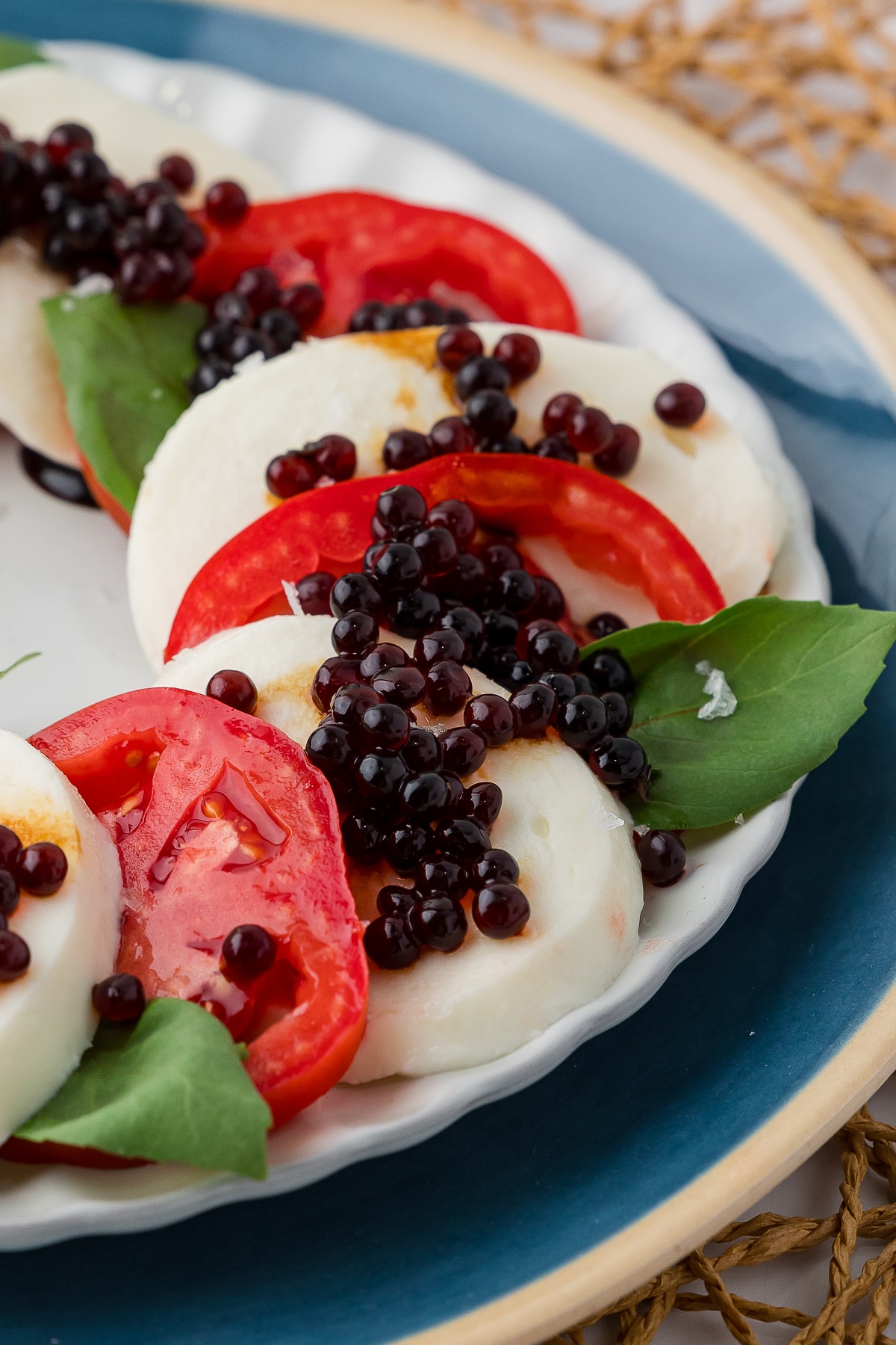 Close up of Balsamic Vinegar Balls on top of a cheese and tomato appetizer tray