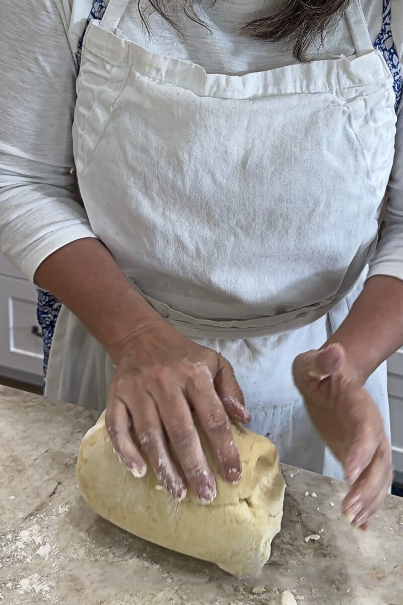 kneading dough on a white countertop
