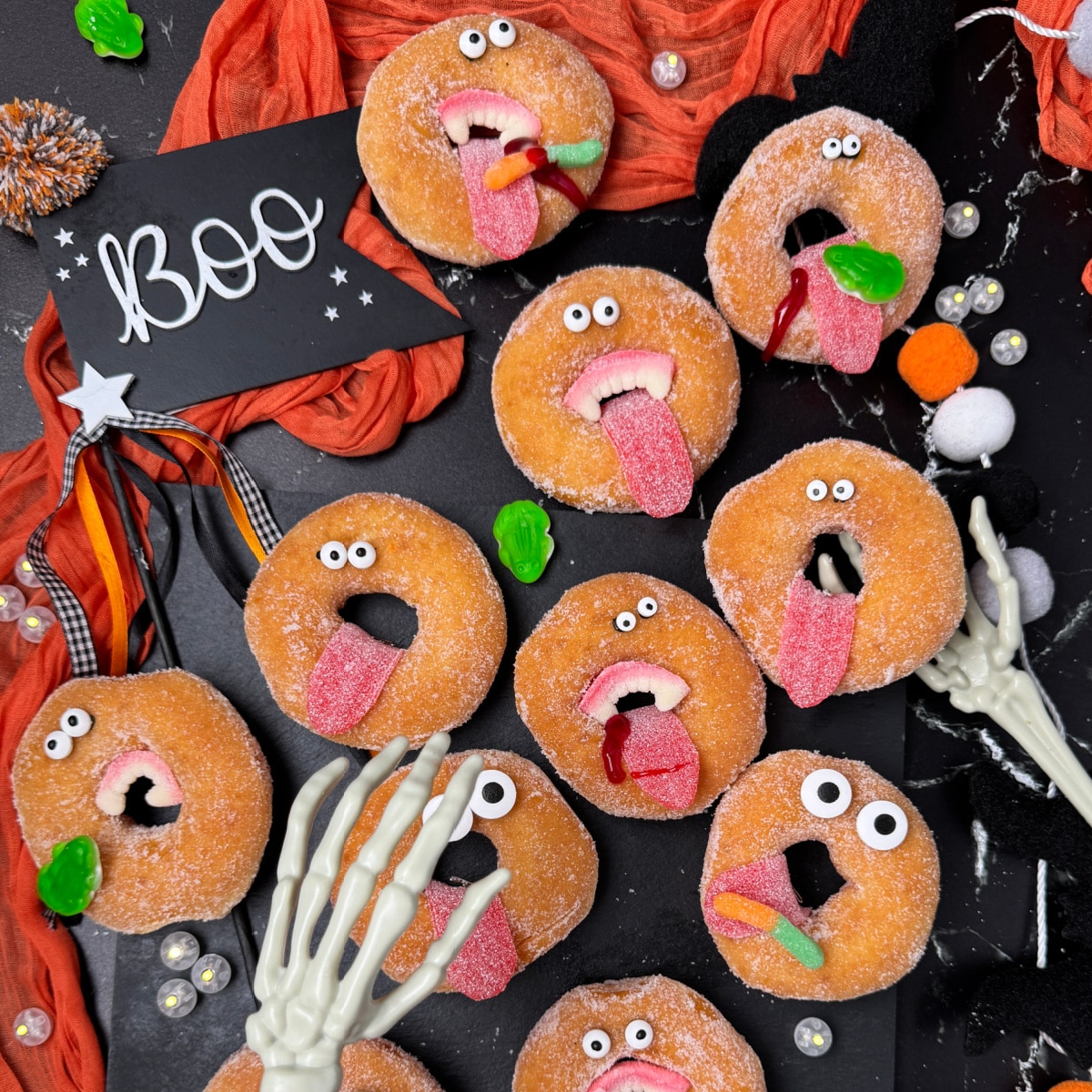 Halloween party treat donuts made with Wilton Candy Eyeballs and gummy tongues and teeth