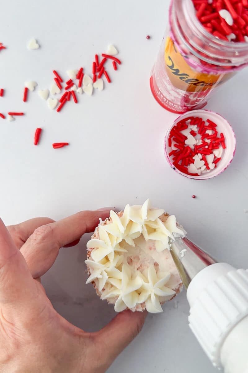 using star tip to make hydrangeas on a cupcake with white frosting