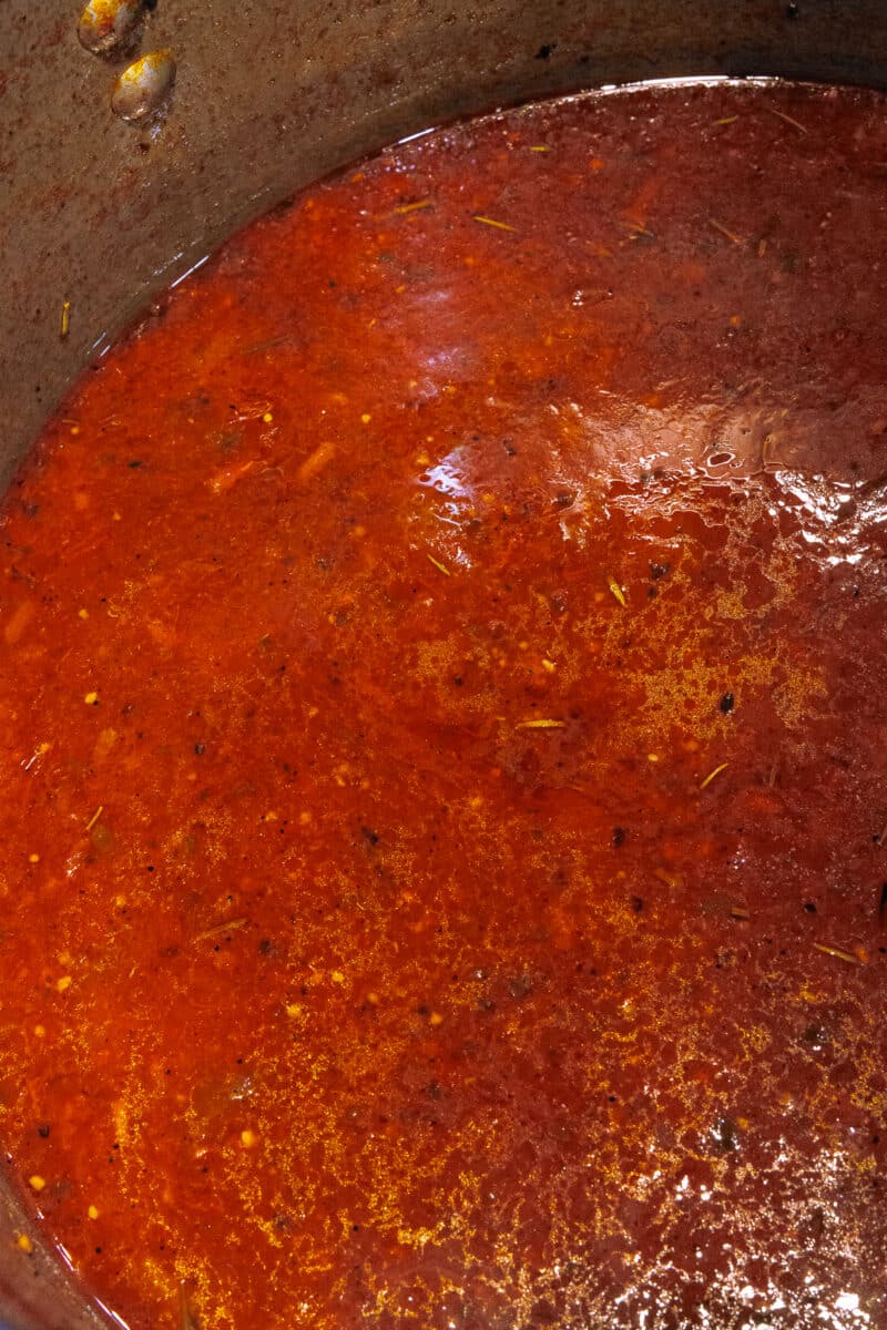 Close-up of deep red tomato sauce that has reduced and thickened during simmering.