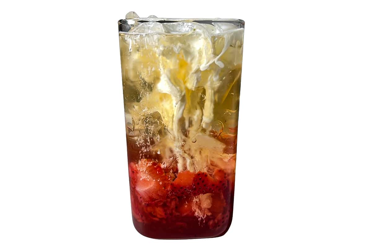 Heavy cream swirling into a Strawberry Lemon Poppi soda, creating a marbled effect.